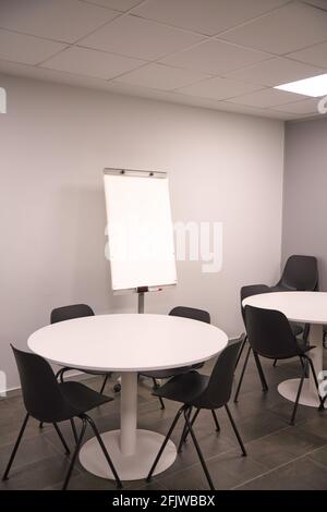 A room filled with furniture and a table with a white board to white in Stock Photo