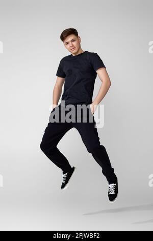 Handsome young man in black t-shirt jumping. Stock Photo