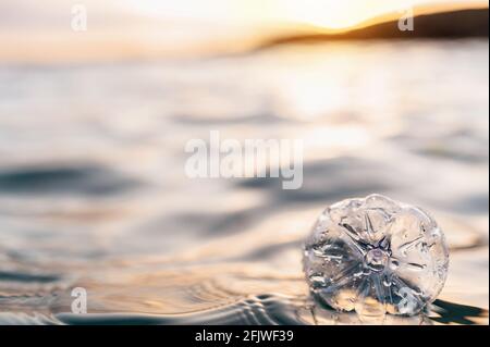 Garbage floating on sea or ocean water with plastic bottles and face masks. Pollution and environmental damage concept. Stock Photo