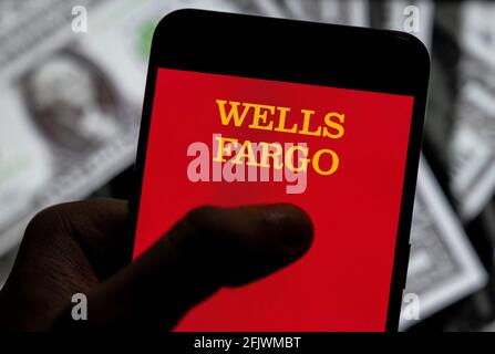 China. 23rd Apr, 2021. In this photo illustration the American multinational financial services company Wells Fargo bank logo seen displayed on a smartphone with USD (United States dollar) currency in the background. (Photo by Budrul Chukrut/SOPA Images/Sipa USA) Credit: Sipa USA/Alamy Live News Stock Photo