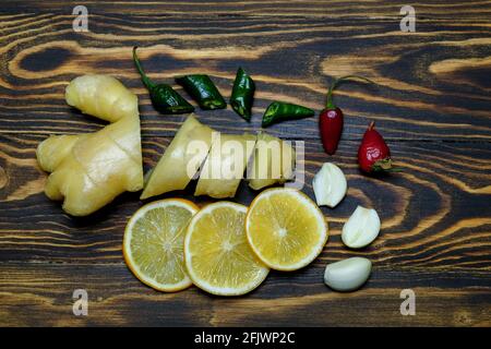 ginger root with lemons, garlic, chili pepper on a wooden background Stock Photo