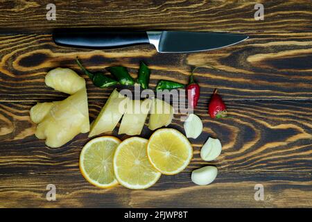 ginger root with lemons, garlic, chili pepper on a wooden background Stock Photo