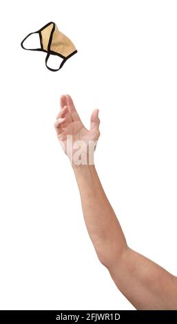A hand pitching a used Covid face mask away, isolated on white with copy space. Stock Photo
