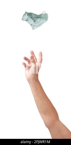 A hand throws a filty blue face mask away, isolated on white with copy space. Stock Photo