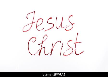 Name Jesus Christ written with blood isolated on white background. Top view. Palm Sunday, Good Friday, Easter concept, Christ resurrection Stock Photo