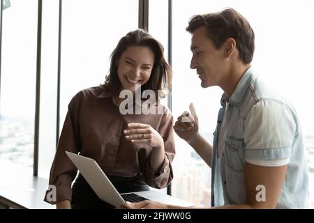 Smiling diverse colleagues have fun working on computer Stock Photo