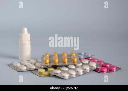 Different medicines- tablets and pills in blister pack, medications drugs and white plastic medical container for nasal spray (decongestant). Close-up Stock Photo