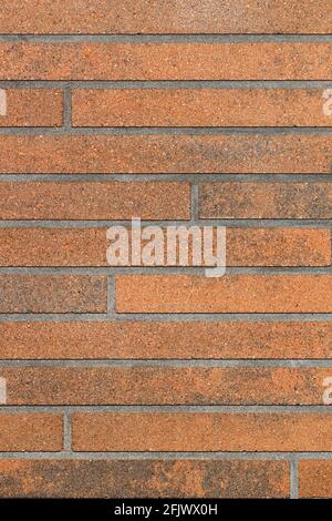 The decorative surface of the wall is brown with a horizontal brown striped surface and imitation of brickwork. Vertical image, copy space. Stock Photo