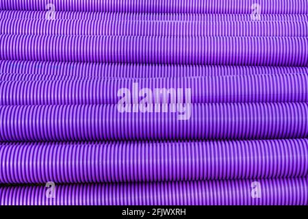 Pattern formed by purple corrugated plastic pipes used for communications cables. No people. Copy space. Stock Photo