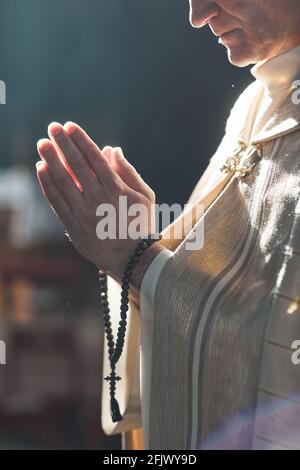 Close-up of priest with rosary beads praying during ceremony Stock Photo