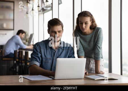 Young employees cooperate using laptop in office Stock Photo