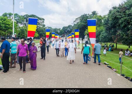 KANDY, SRI LANKA - JULY 19, 2016: White clothed Buddhist devotees at the grounds of the Temple of Sacred Tooth Relic during Poya Full Moon holiday. Stock Photo