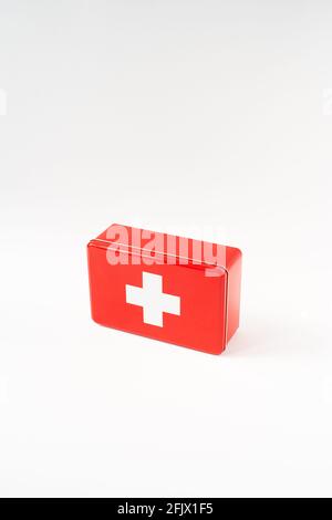 Red simplistic first aid box, white background, high key, vertical format Stock Photo