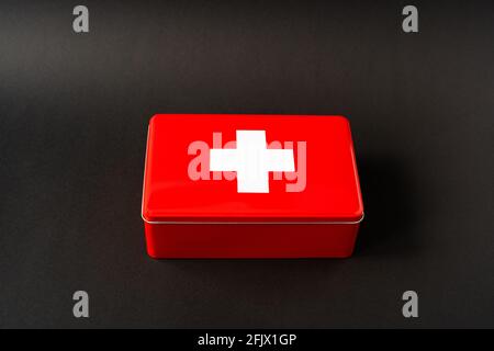 Red simplistic first aid box, black background with light gradient Stock Photo