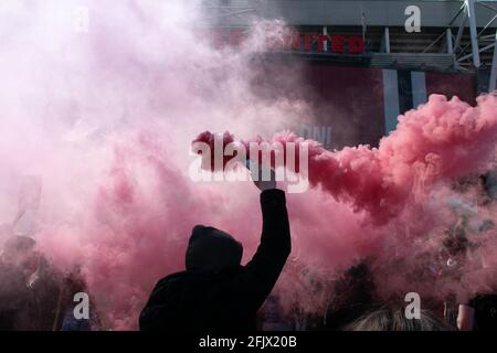 Protest against Glazer at Old Trafford football ground. Supporter holding red smoke flare. Manchester United stadium, UK.