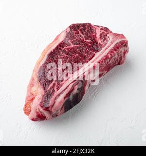 Dry aged club steak set, square format, on white stone surface Stock Photo