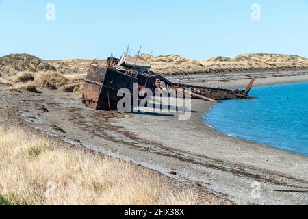 Wreckages, abandoned rusty stranded boat on San Gregorio beach in the south of Chile at the strait of Magellan Stock Photo