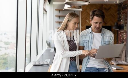 Diverse employees engaged in team discussion on computer Stock Photo