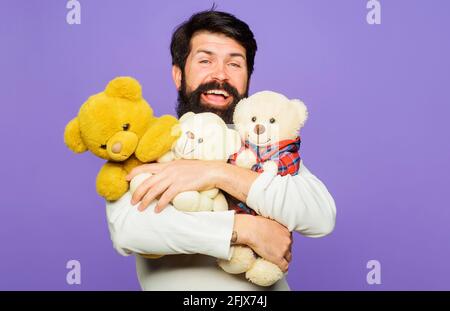 Smiling bearded man hugs Teddy bears. Happy Bearded man with plush toys. Gift and present. Stock Photo