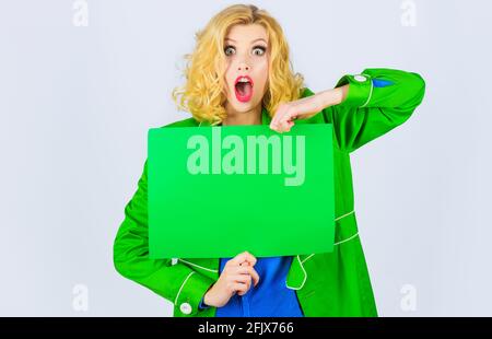 Surprised woman with sign board with Copy space for text. Amazed girl with Advertisement banner. Stock Photo