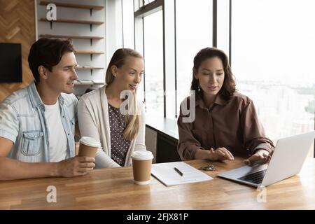 Female relator consult excited couple clients in office Stock Photo