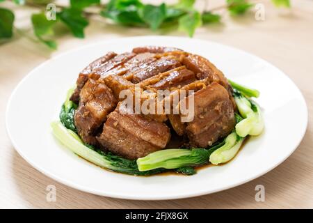 Braised pork belly with yam served with green vegetable Stock Photo