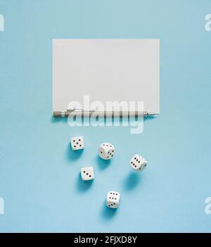 Dice game in progress. Rolling dice, pencil and score sheet on a blue background. Stock Photo