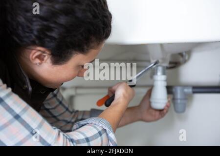 female plumber working on central heating boiler Stock Photo
