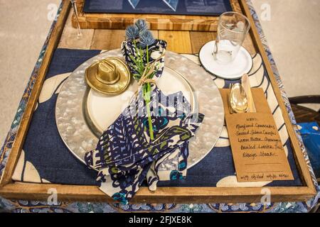 Cowboy - western place setting for one on rustic wooden tray - silverware in brown manila envelope with menu written on it Stock Photo