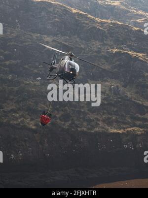 Killarney National Park, Ireland - 26th April.  2021: Helicopter collecting water to extinguish fire in Killarney National park Stock Photo