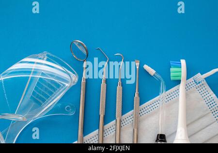 Dentist tools on blue surface close up. Professional Dental Hygiene cleaning tools. Calculus and Plaque Remover Set, Dental Scaler And Mouth Mirror In Stock Photo