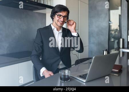 Businessman with headset at a video conference from his home computer Stock Photo