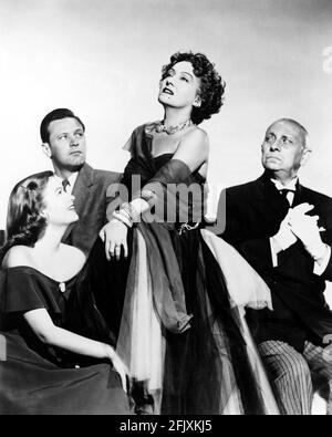 1951 , USA : The movie actress   GLORIA SWANSON ( 1898 - 1983 ) , as Norma Desmond, with WILLIAM HOLDEN , NANCY OLSON , ERICH VON STROHEIM  in SUNSET BOULEVARD ( Viale del Tramonto ) by Billy Wilder, costume by Edith HEAD , Paramount pubblicity still - FILM - CINEMA - attrice cinematografica - VAMP  - DIVA - DIVINA - DIVINE - spalla - spalle - shoulder - shoulders - orecchino - orecchini - clips - earring - earrings - eardrop - eardrops - - gioielli - gioiello - jewel - jewels - jewellery - bijoux - bigiotteria - diamanti - diamante - diamond - diamands - collana - collier - necklace - smile - Stock Photo