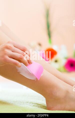 Young woman in Spa getting legs creamed for hair removal Stock Photo
