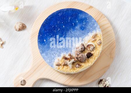 No baked ocean blue cheese cake with chocolate seashells decoration Stock Photo