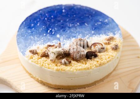 No baked ocean blue cheese cake with chocolate seashells decoration Stock Photo