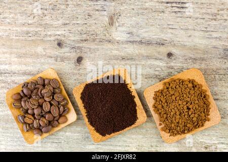 Roasted coffee beans, Ground coffee, Granule instant coffee in bowl, on wooden background, top view Stock Photo