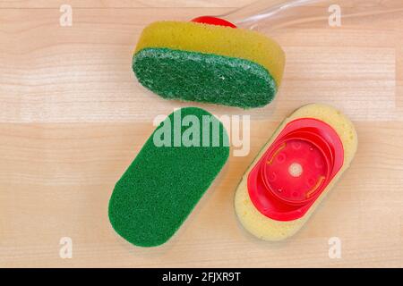 Old used and unused new dish washing heavy duty sponge with quick and easy refill clip on, on wooden background, top view with copyspace Stock Photo