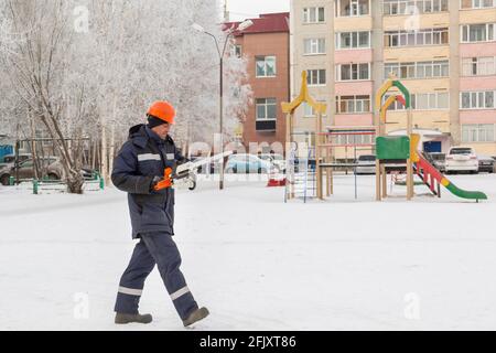 Worker with a chainsaw in hand at the assembly site Stock Photo