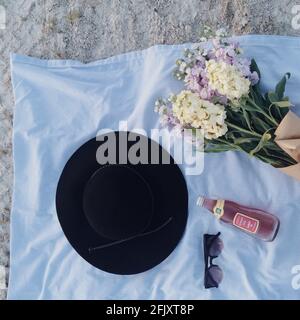 Picnic at Crandon Park in Key Biscayne, Florida, with some larkspur flowers, hat and a soda pop, European Soda, from The Fresh Market. Stock Photo