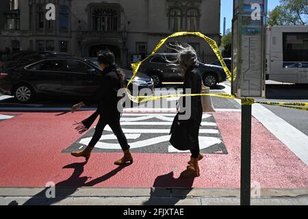 New York, USA. 26th Apr, 2021. People walk past yellow police tape on the corner of 5th Avenue and 79th street, set up after a suspicious package was reported near the entrance of the Metropolitan Museum of Art a few blocks away, New York, NY, April 26, 2021. Streets were reopened after the NYPD Bomb squad declared the all clear after inspecting what turned out to be a just a suitcase. (Photo by Anthony Behar/Sipa USA) Credit: Sipa USA/Alamy Live News Stock Photo