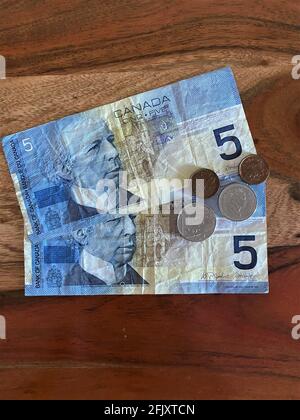 Canadian bills, currency, bank  and coins on a wooden background Stock Photo