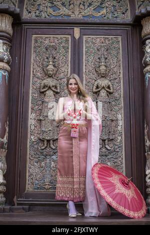 Beautiful girl in the Thai national bright dress with oriental makeup, travel in Thailand Stock Photo