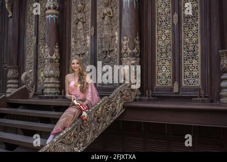 Beautiful girl in the Thai national bright dress with oriental makeup, travel in Thailand Stock Photo