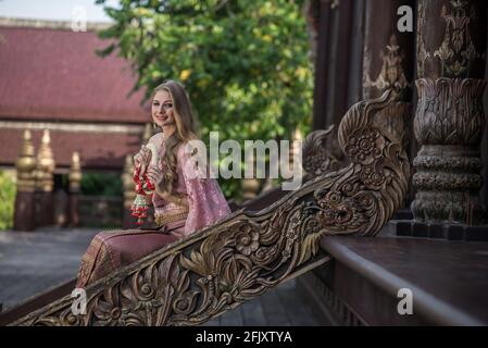 Beautiful girl in the Thai national bright dress with oriental makeup, travel in Thailand Stock Photo