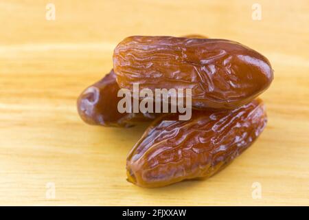 Closeup of natural dried dates fruit on wooden background (Phoenix dactylifera) Stock Photo