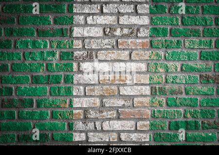 National flag of Nigeria  depicting in paint colors on an old brick wall. Flag  banner on brick wall background. Stock Photo