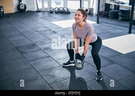 Dark-haired young woman performing a strength exercise Stock Photo