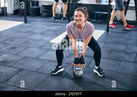 Joyous athlete posing for the camera during the weight-lifting workout Stock Photo
