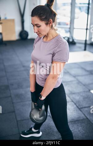 Serious dark-haired sportswoman doing a strength exercise Stock Photo